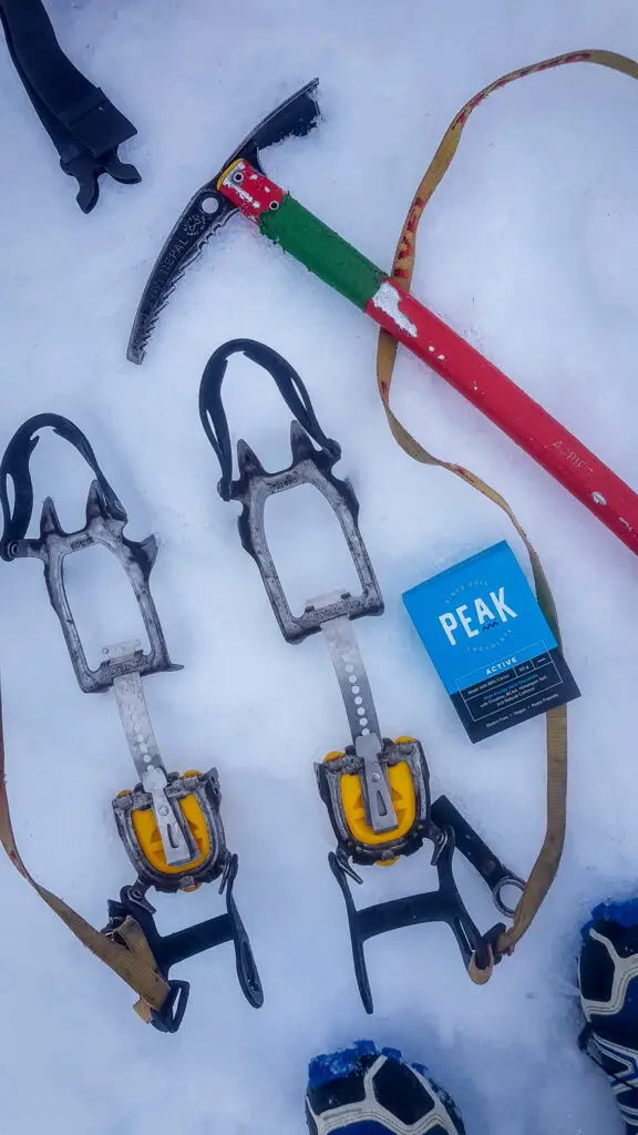 Crampons, ice axe and chocolate sitting in the snow