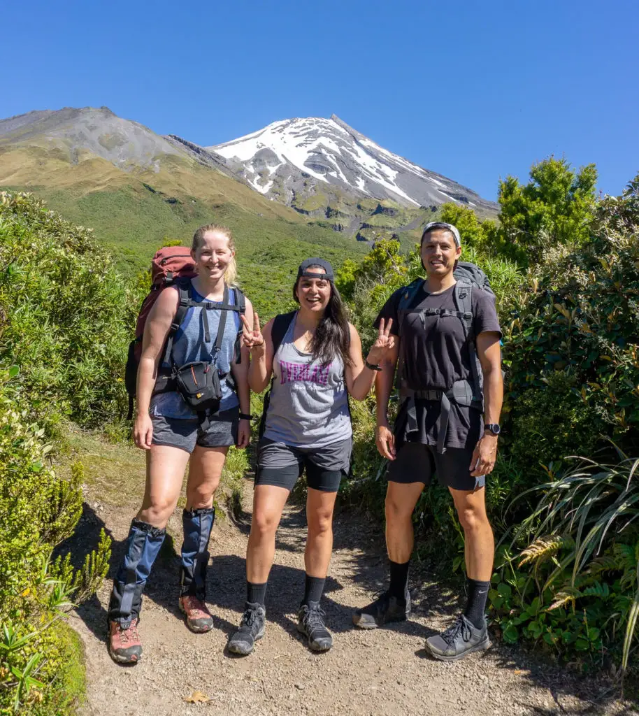 Happy trampers in front of Fanthams Peak and Taranaki