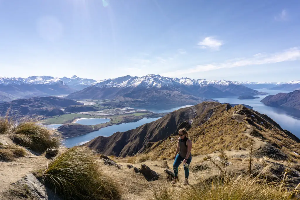 Female hiker climbing back from the Roy's Peak viewpoint with Mt Aspiring in the background