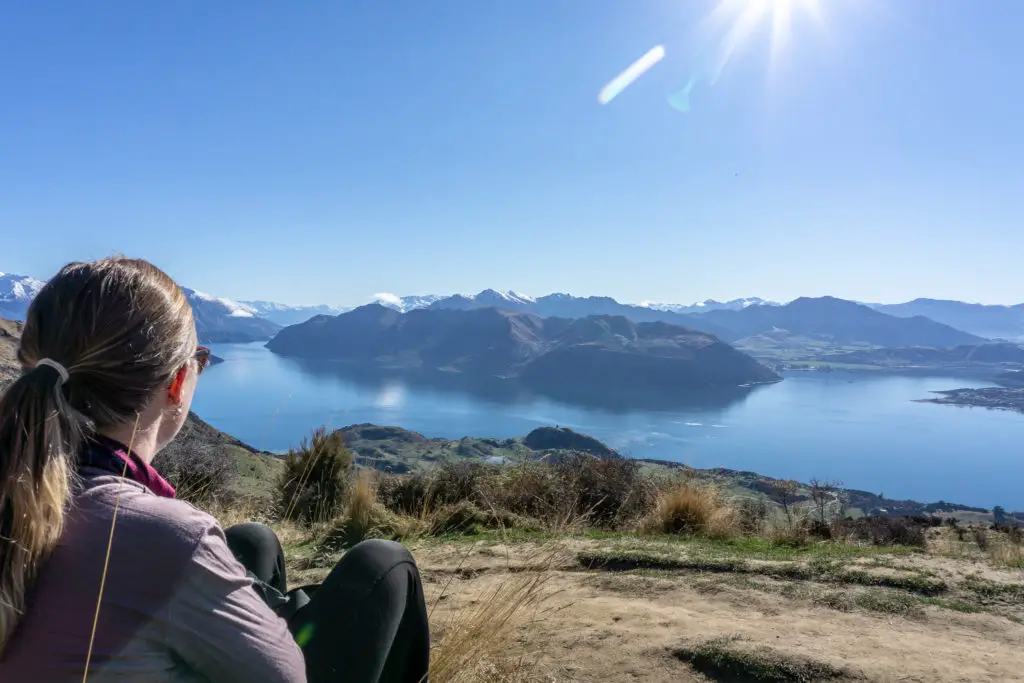 View of a hiker's shoulder of Lake Wanaka from the Roys Peak track