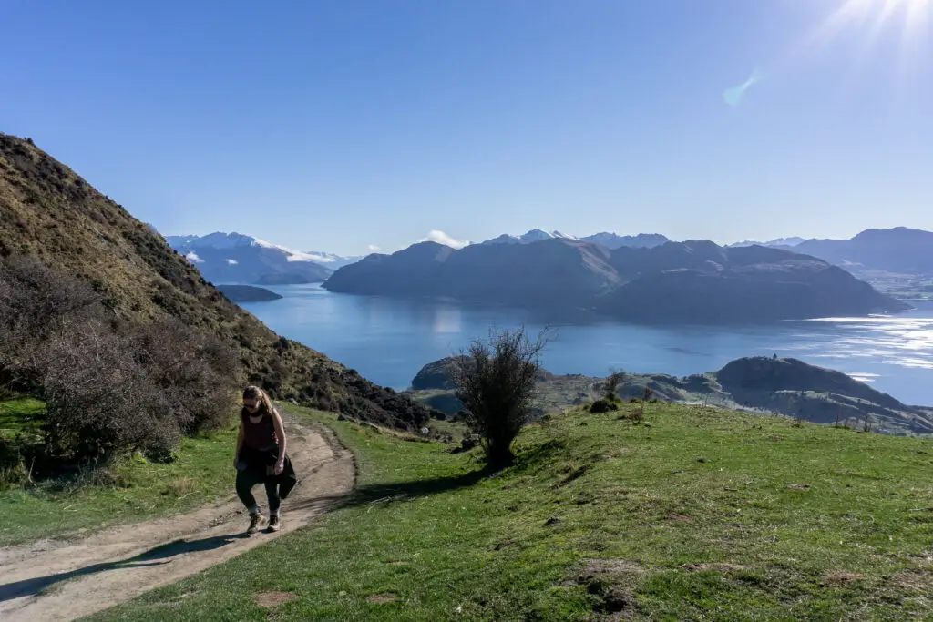 Female hiker climbing up the Roys Peak track with views of Lake Wanaka in the background