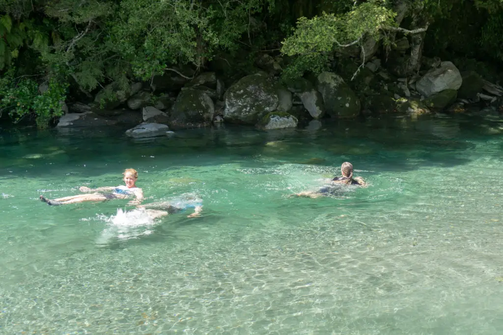 Three girls swimming in the Haast River after two nights up at Brewster Hut
