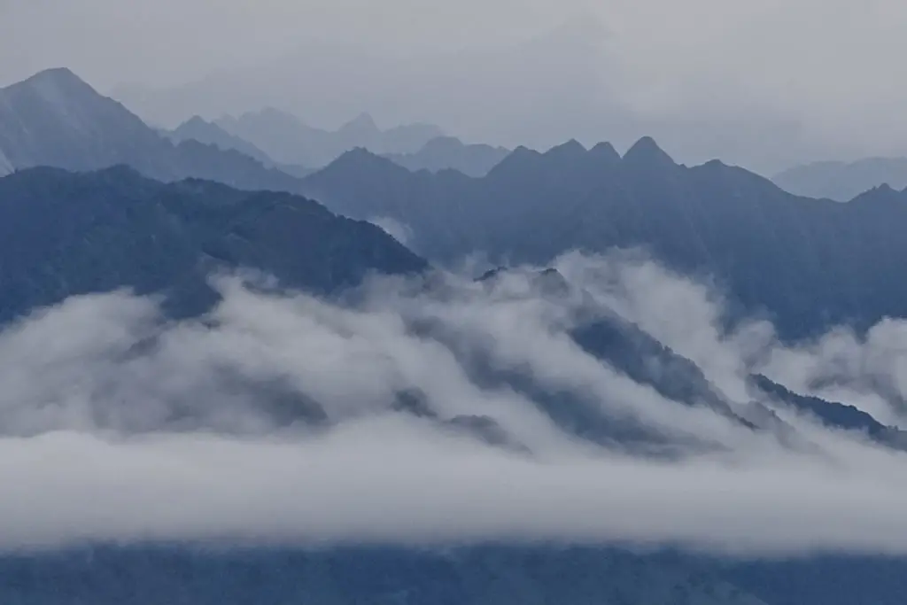 Hazy blue ridgelines fading into the background with cloud covering their slopes