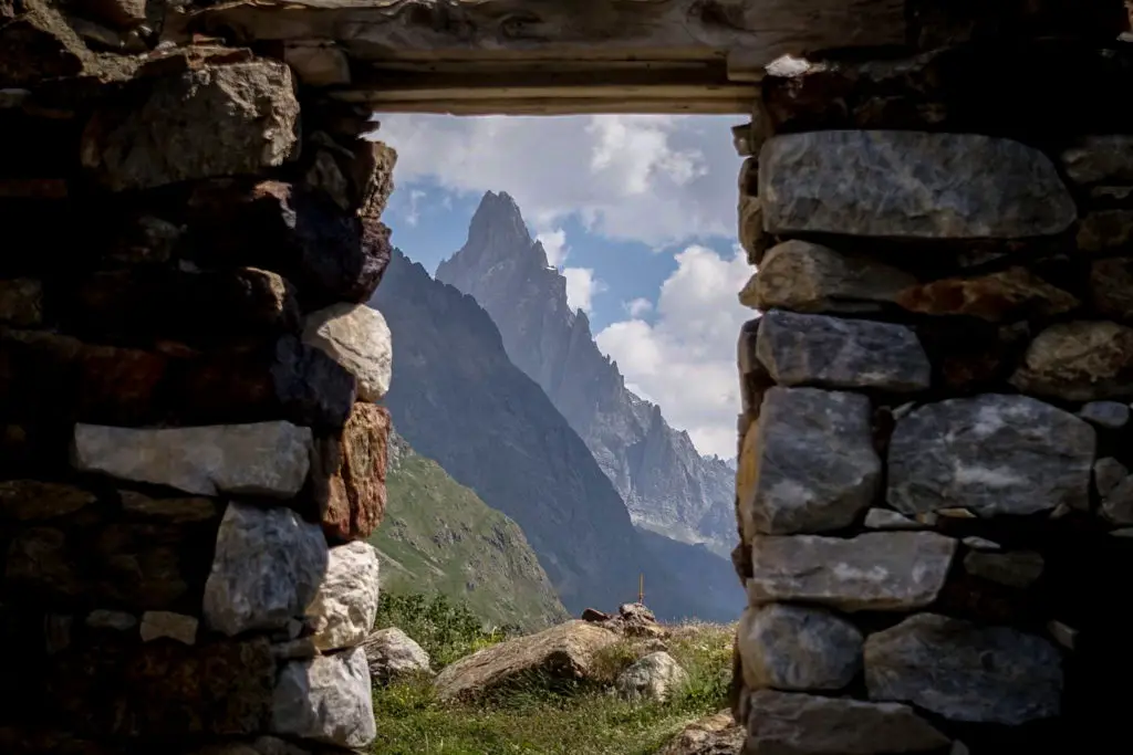 View of a peak in the Dolomites through the window of an old hut
