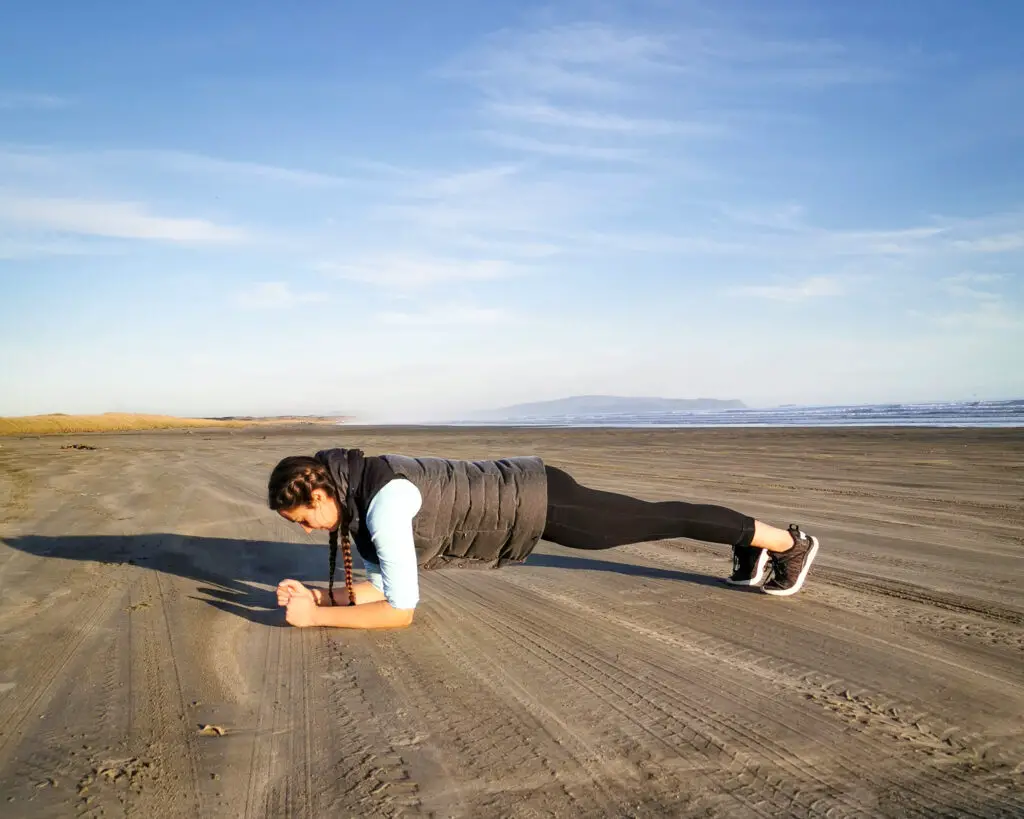 Girl doing a plank on a beach