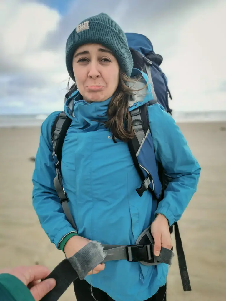 Female hiker looking very sad while holding her broken back strap