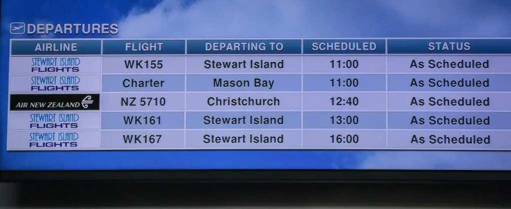 Departure board at Invercargill airport with a charter flight to Mason Bay, Stewart Island scheduled for 11:00