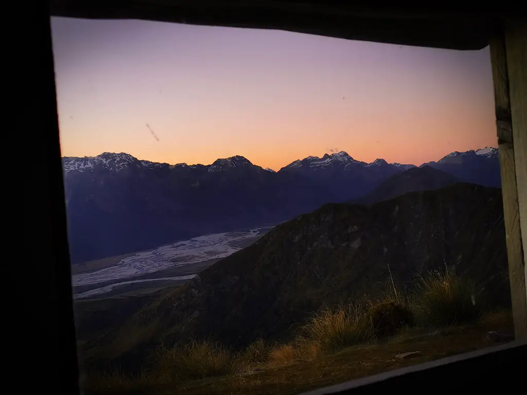 Sunset over Glenorchy and the Humboldt mountains from the window of Heather Jock Hut in Whakaari Conservation Area