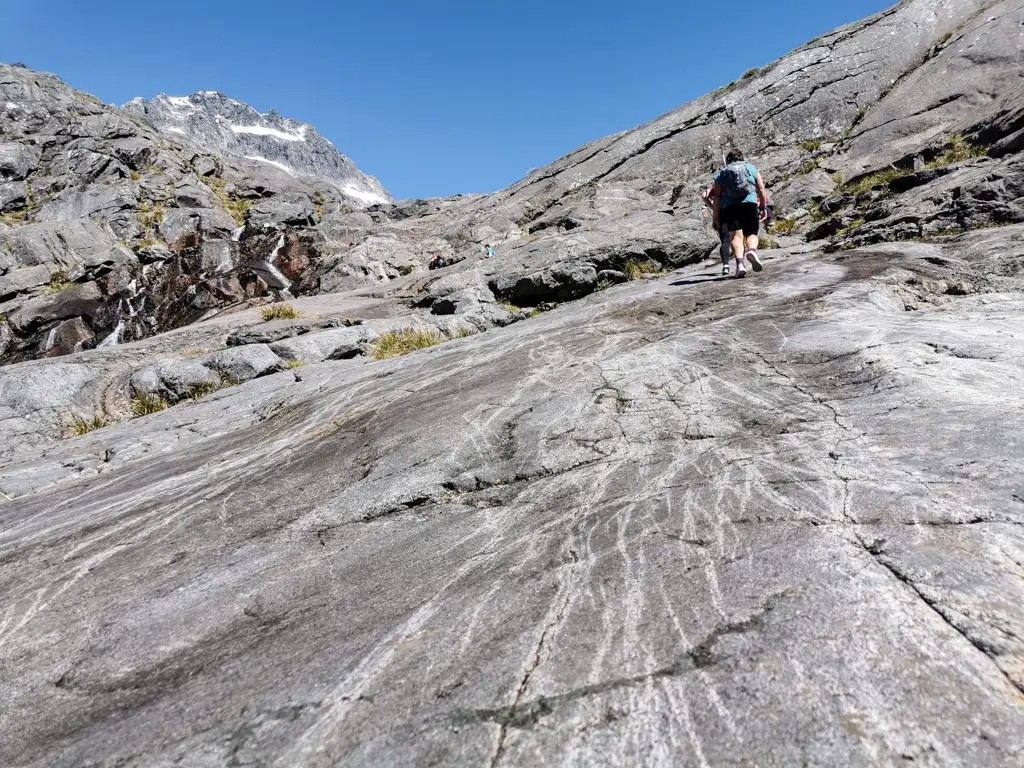 Hiker climbing up rock slabs towards Black Lake
