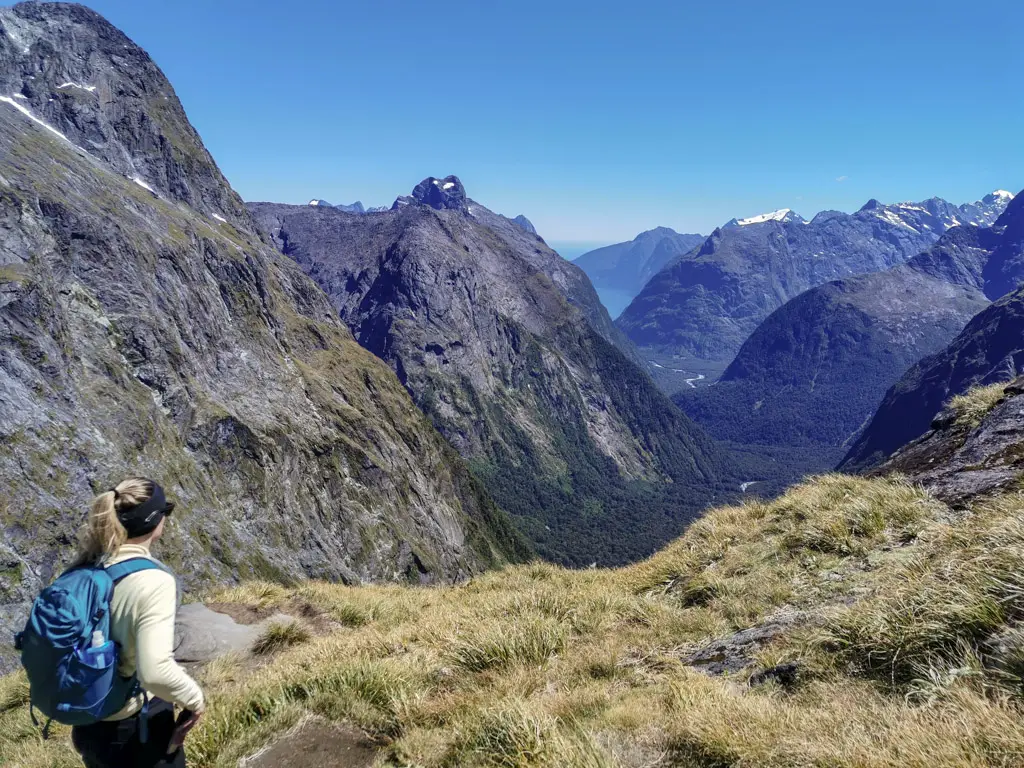 Lade hiker at the top of Gertrude Saddle looking towards Milford Sound and the Tasman Sea in Fiordland National Park