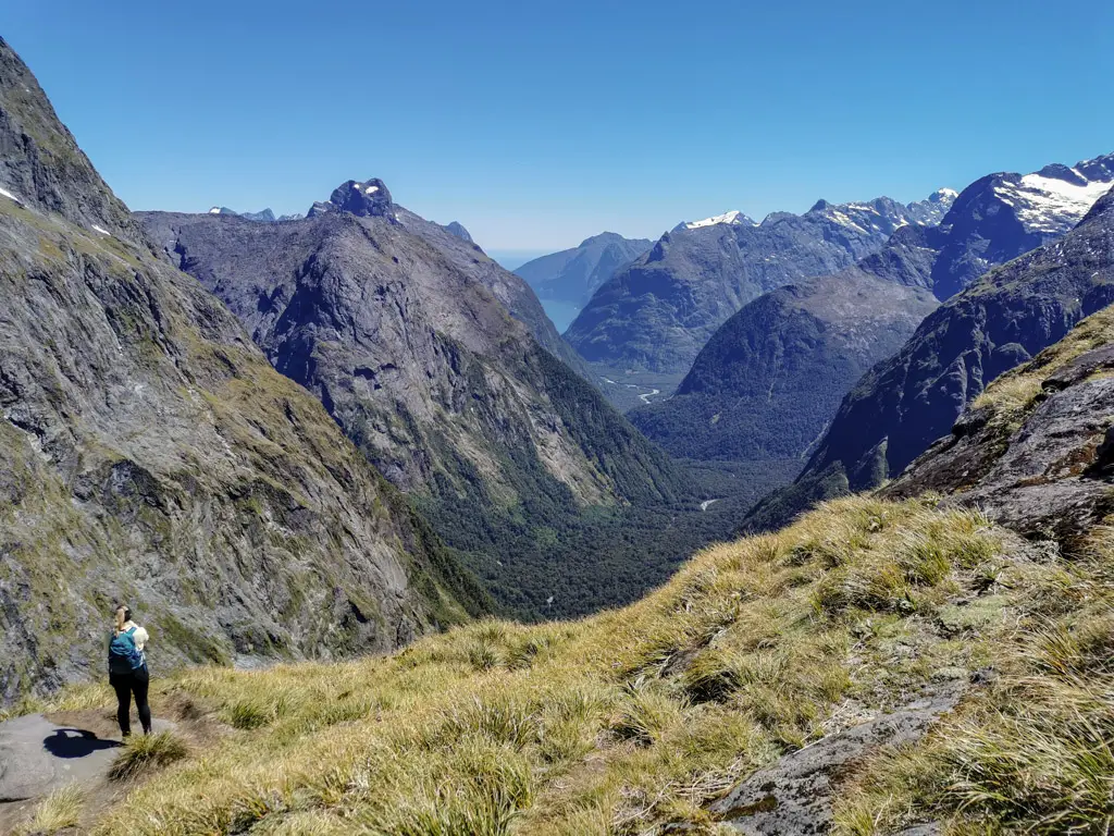 Female hiker at the top of Gertrude Saddle looking across to Milford Sound in Fiordland National Park