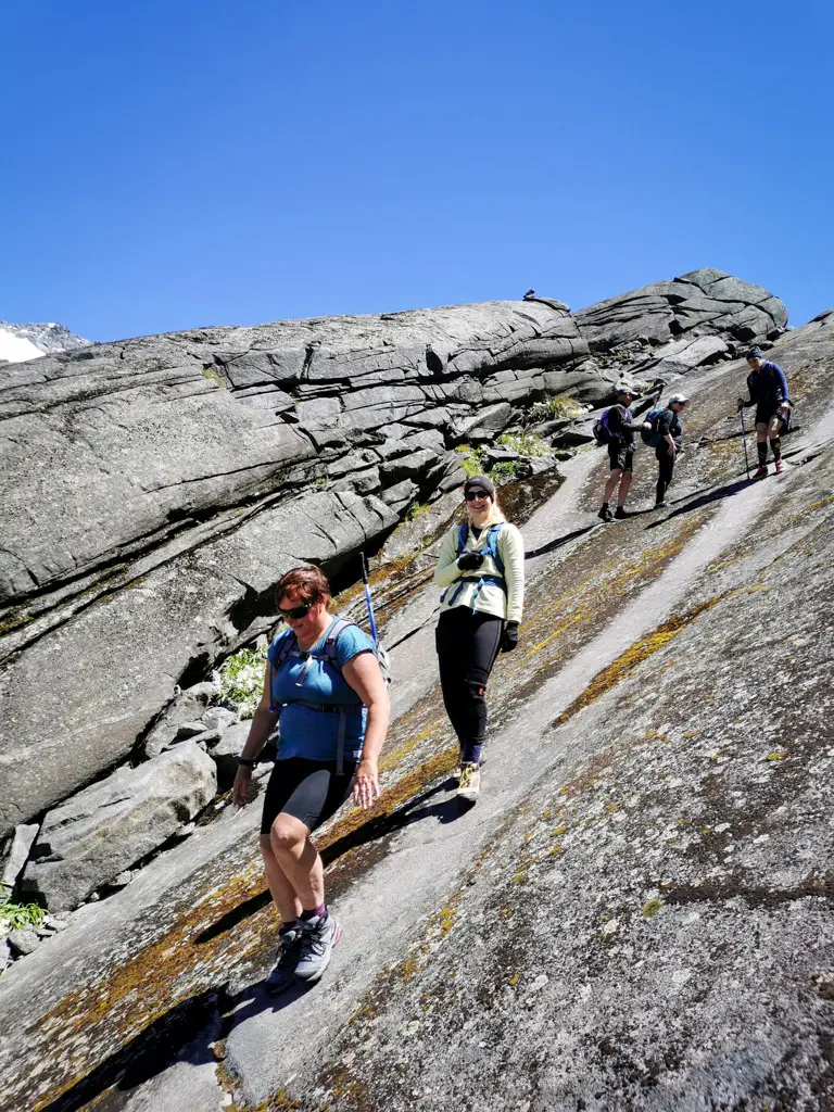 Group of hikers walking down a steep rock slab