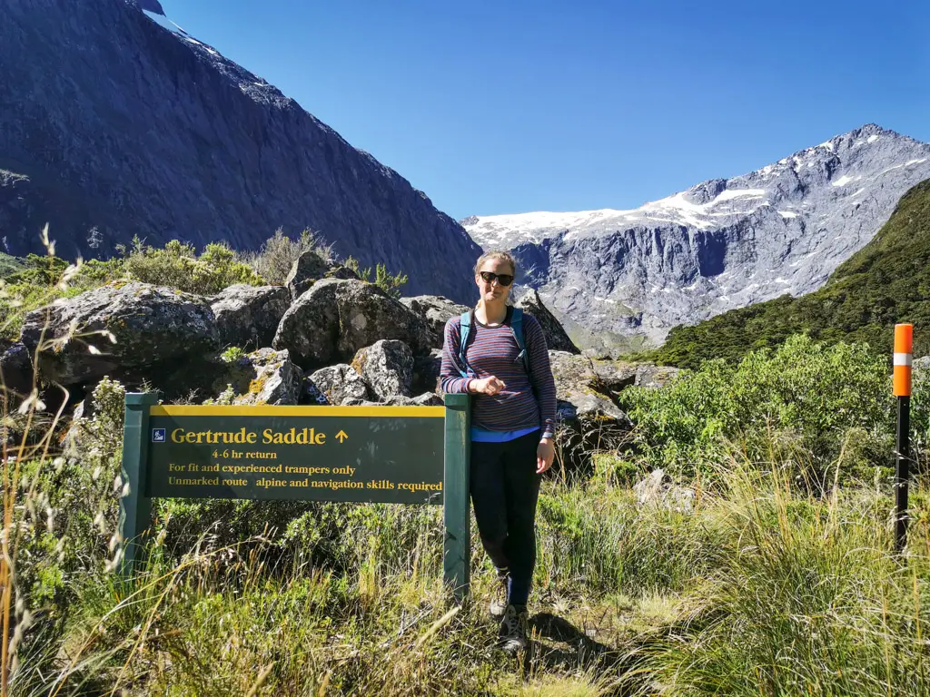 Female hiker in front of the sign for Gertrude Valley hike