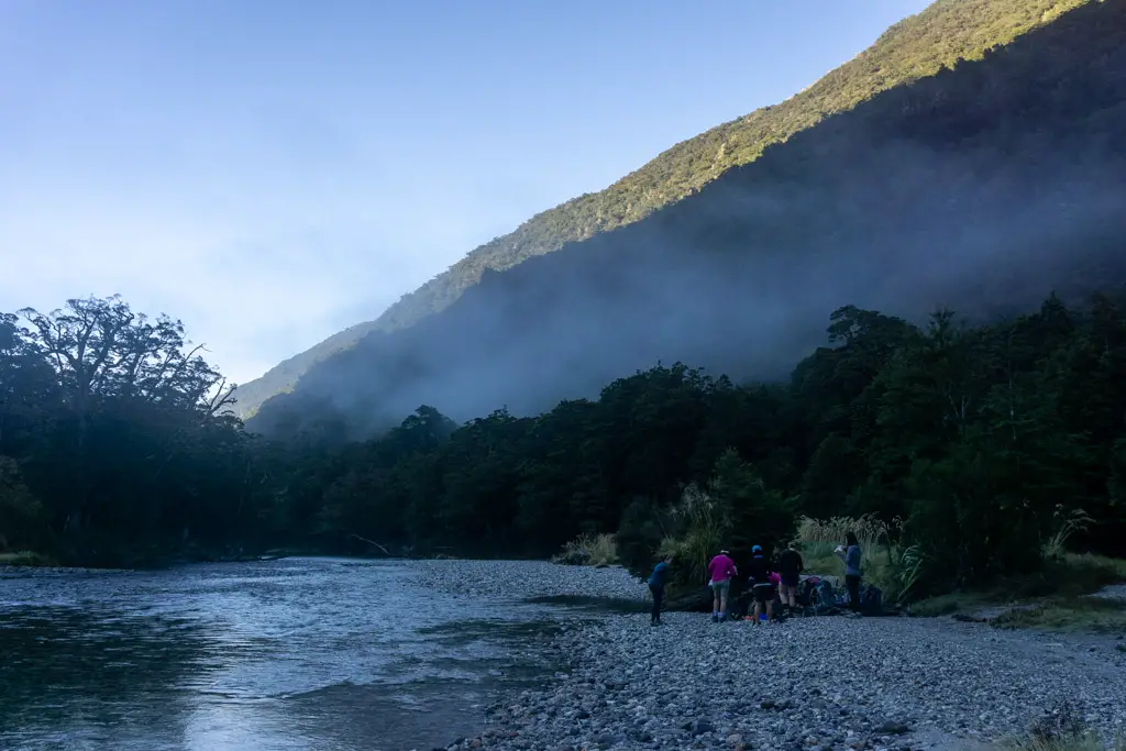 Hikers next to the Clinton River with morning mist rising off the water