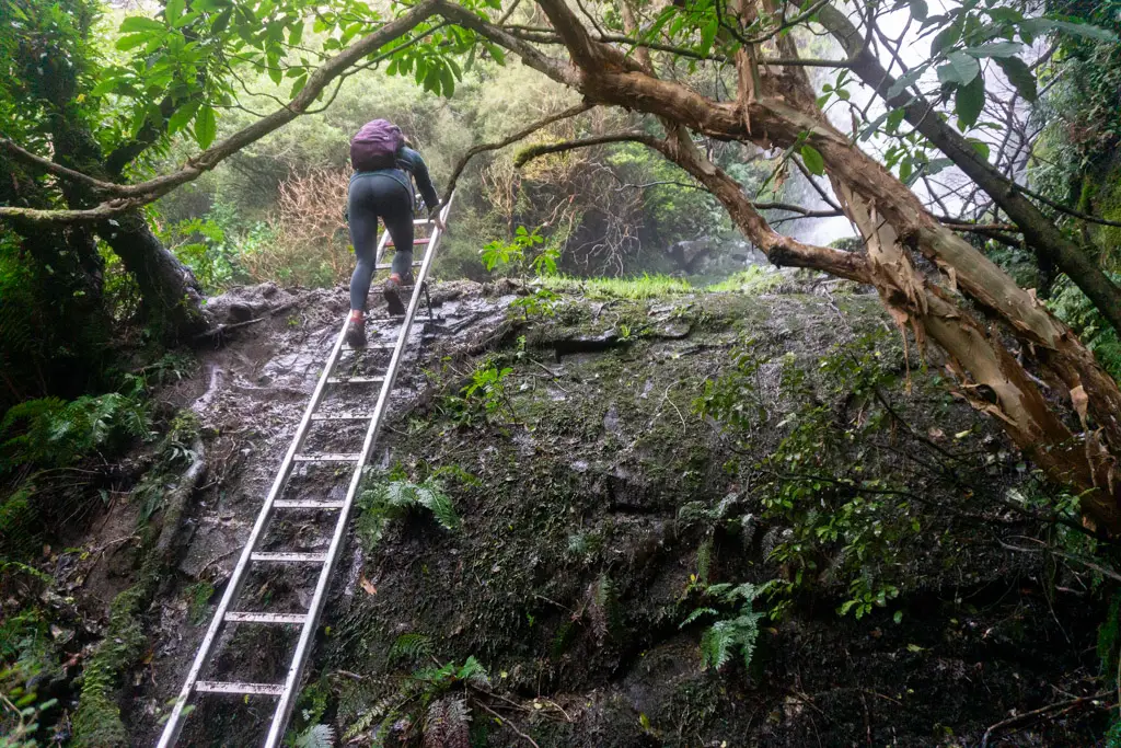 Lady climbing up a steel ladder below Makarewa Falls