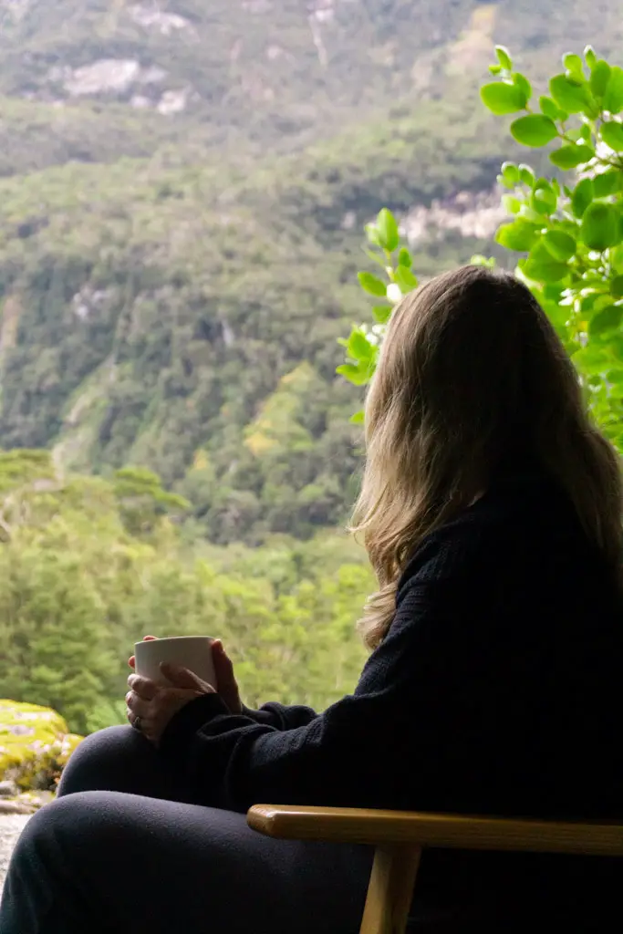 Woman relaxing on a chair with a hot drink in Milford Sound Lodge