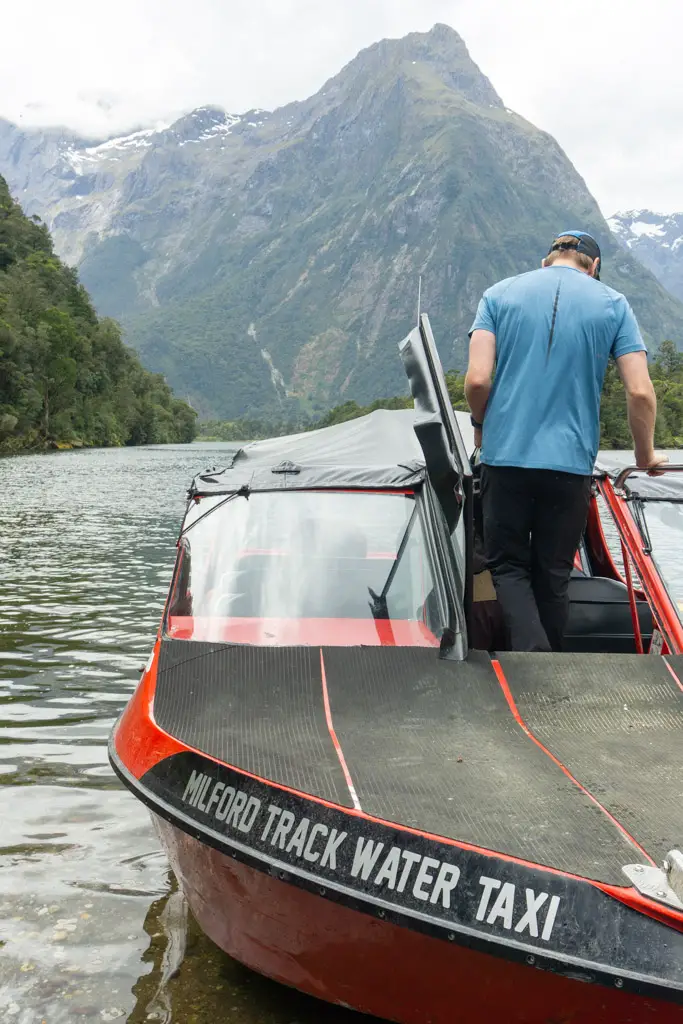 Man boards the Milford Track Water Taxi run by Fiordland Outdoors