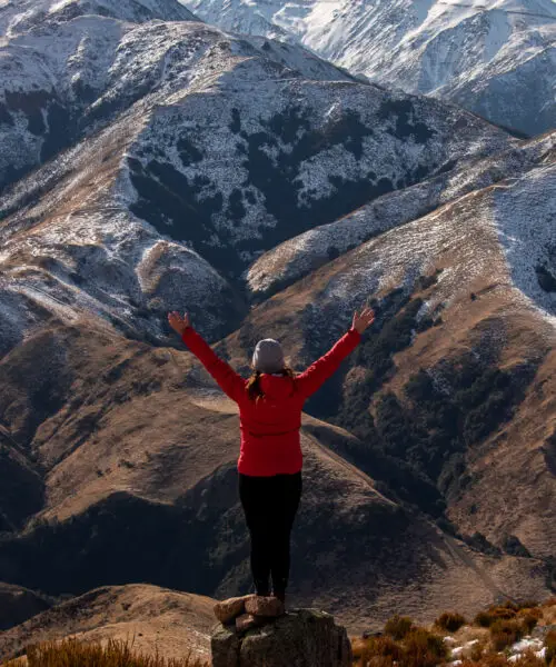 Woman standing in front of snowy mountains