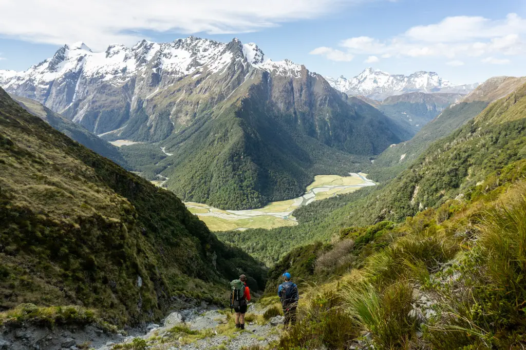 Two trampers on the Emily Pass Route looking down at Routeburn Flats from Emily Creek