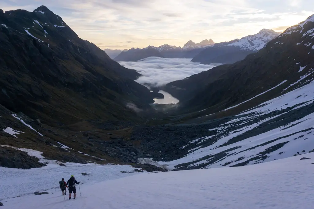 Trampers descending snow slopes above Lake Mackenzie