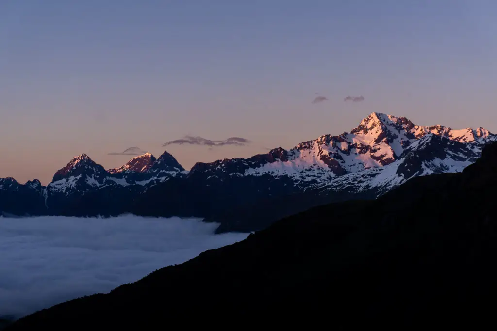 Sunrise with pink snowy mountains and an inversion layer of clouds