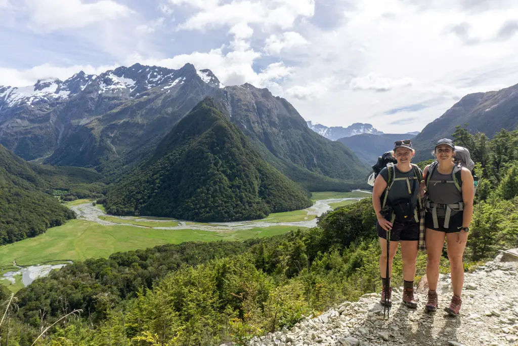 Two trampers posing for a photo on a slip above Routeburn Flats Hut