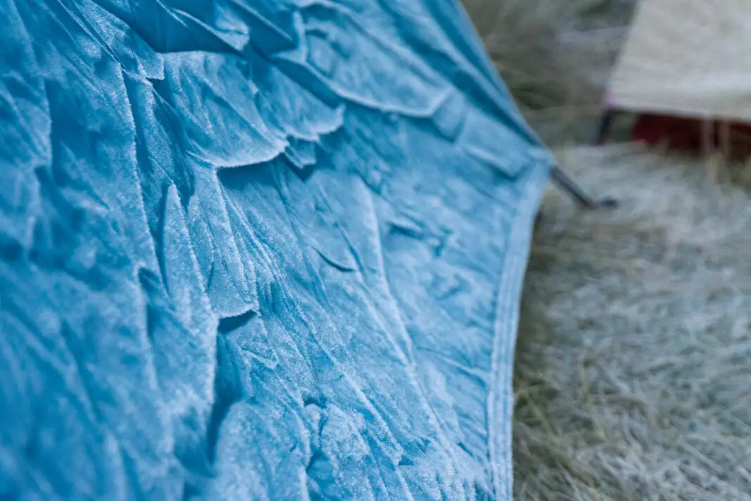 Photo of a blue tent frozen in winter