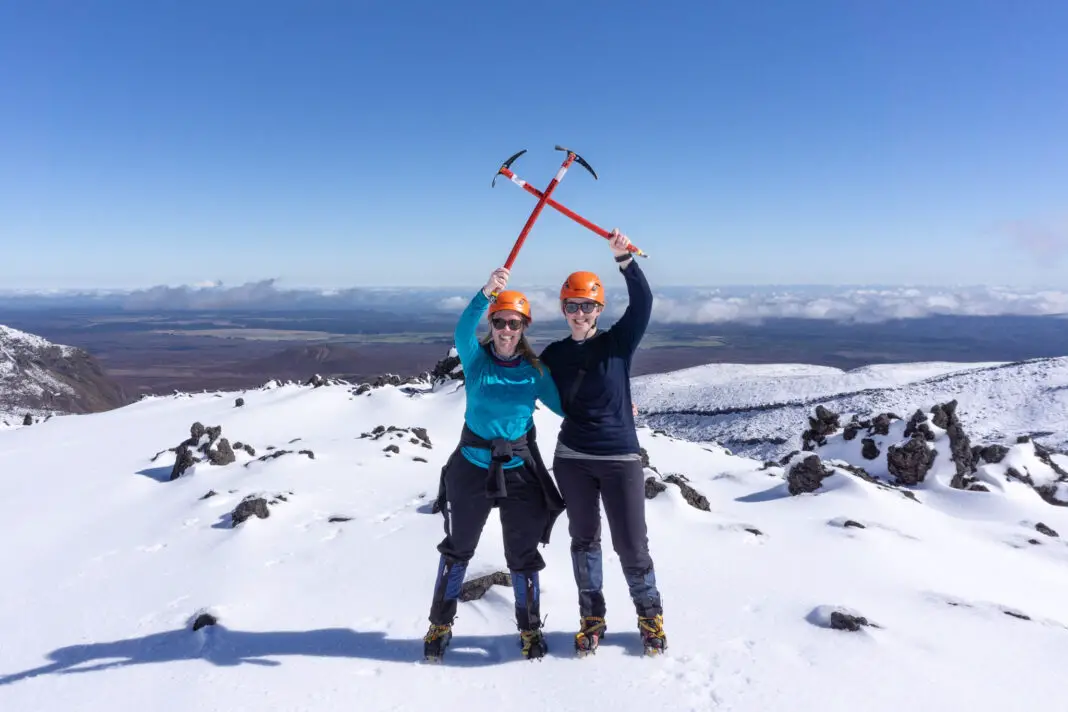 Women on the Tongariro Crossing in winter holding up ice axes