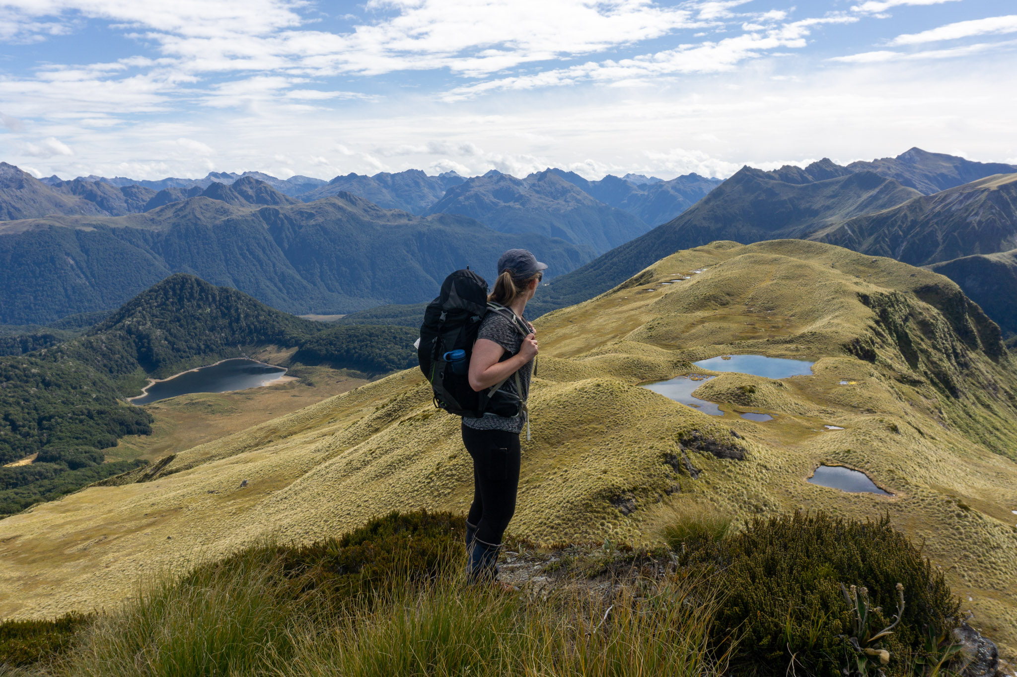 Woman with the Mt Burns tarns near Borland in the background