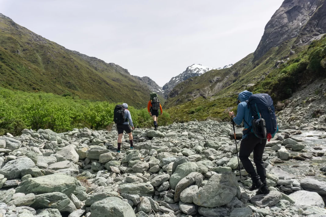 Three trampers walking up the North Branch of the Routeburn with North Col in the background