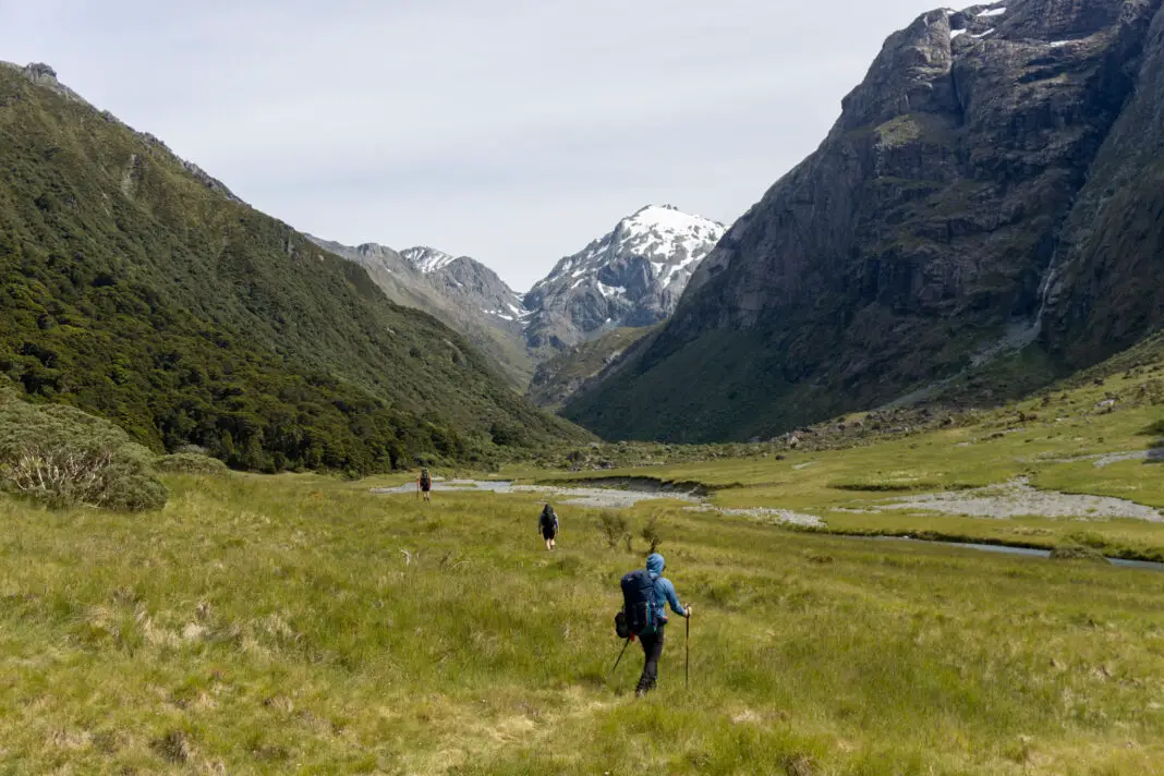 Three trampers walking up the North Branch of the Routeburn with North Col visible in the background