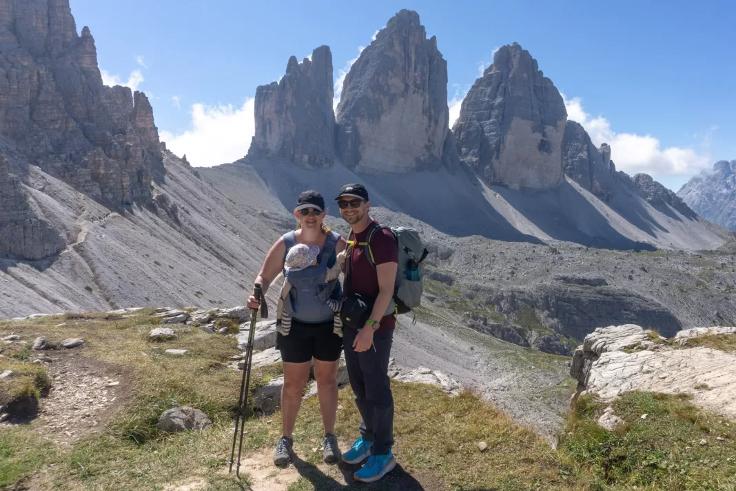 Two adults with baby in front of Tre Cime di Lavaredo