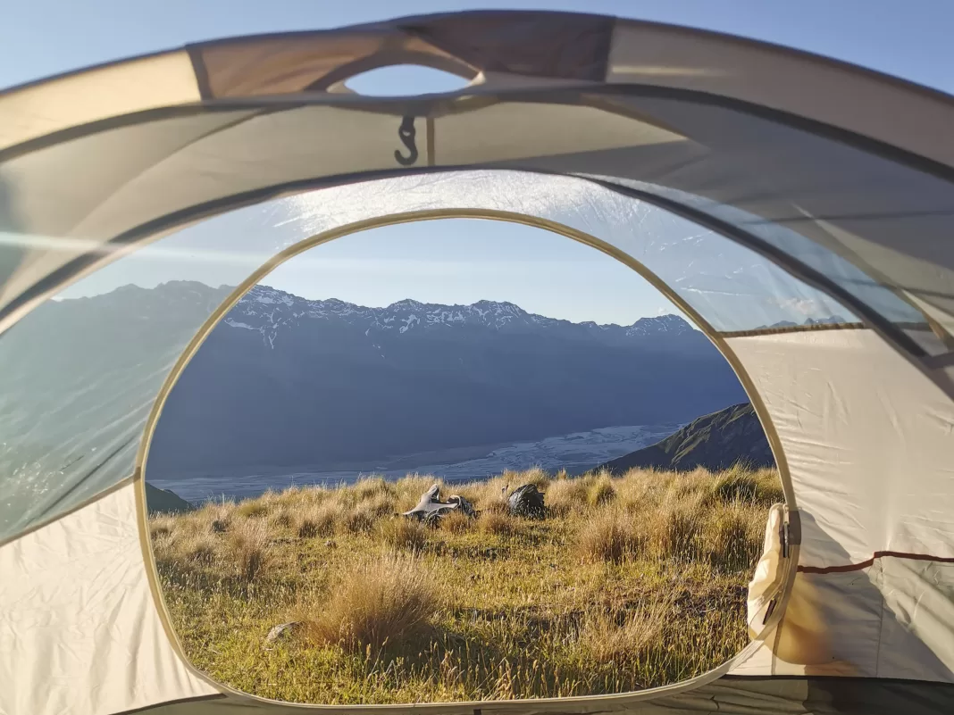 View from a tent with mountains and a river valley in the background