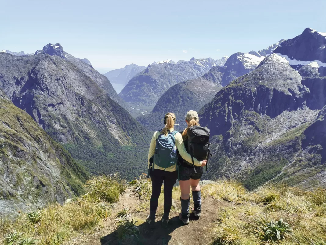 Two women standing at the top of Gertrude Saddle, one of the best Te Anau day hikes