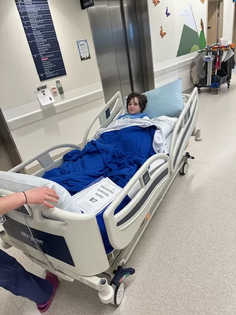 Child in a hospital bed being moved down the hallway 