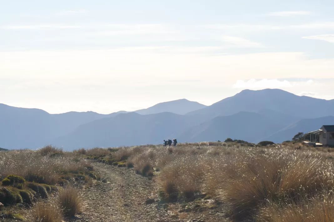 Three trampers leaving Sylvester Hut