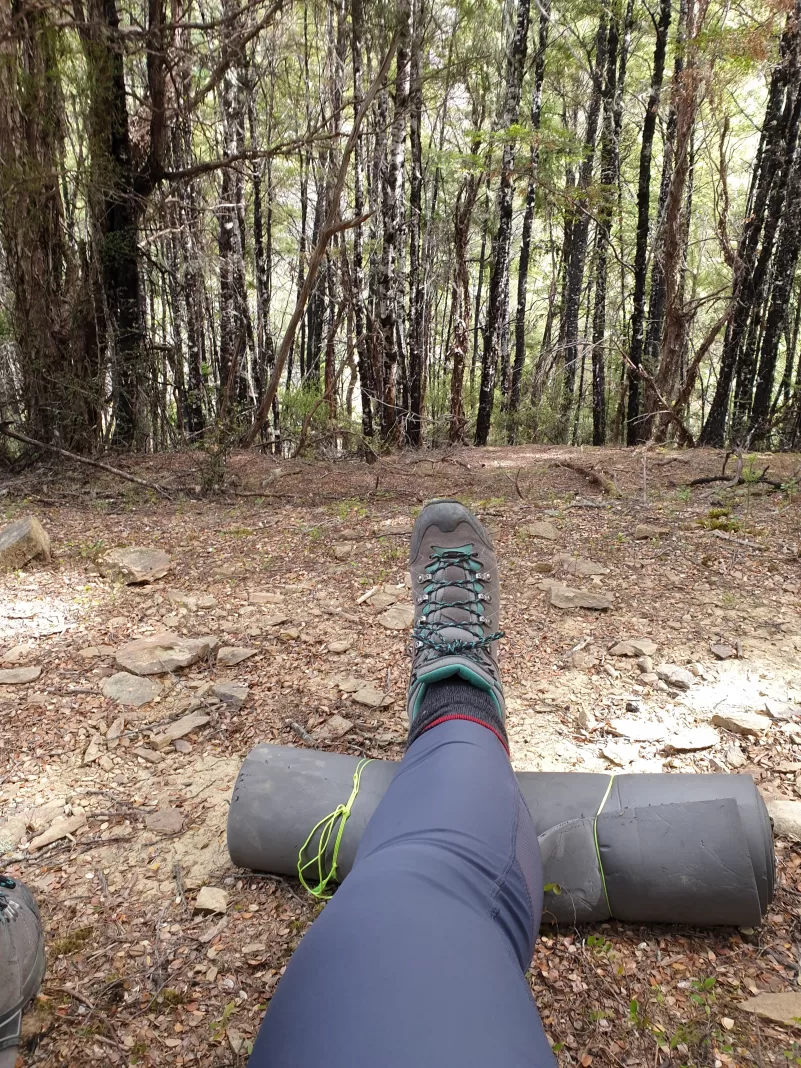 Leg with a tramping boot propped up on a bag