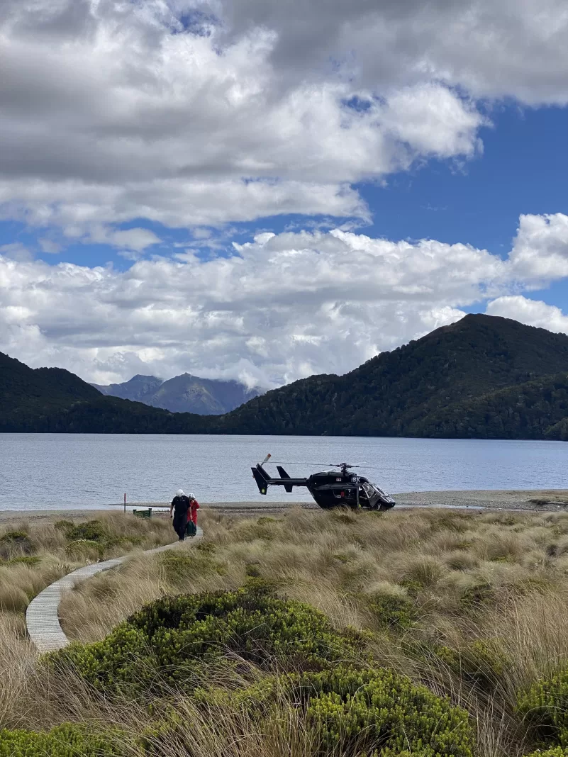 Helicopter landed on the shores of Green Lake near Green Lake Hut