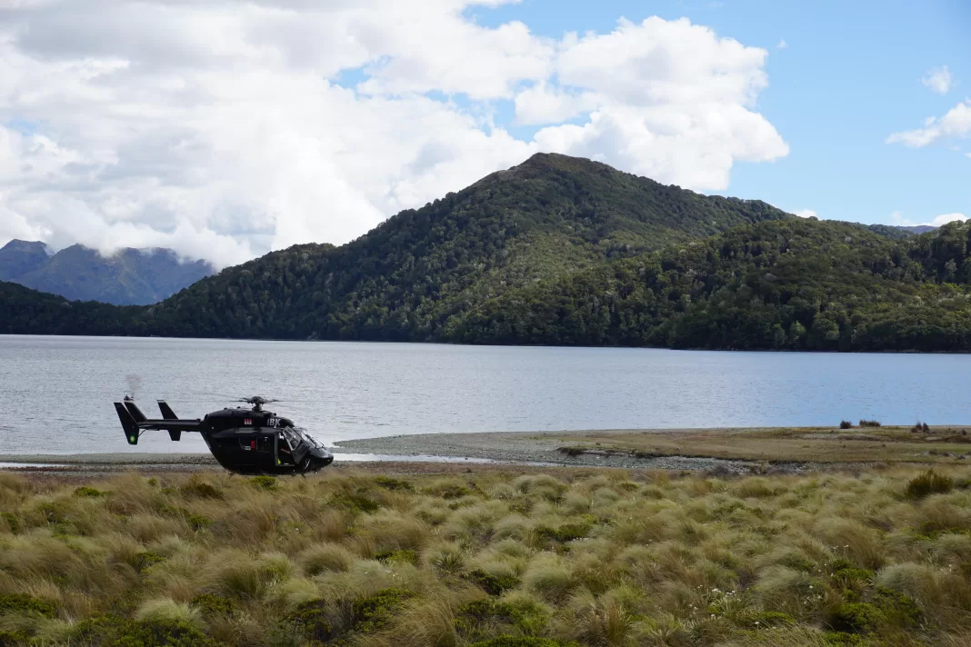 Helicopter landed on the shores of Green Lake in Fiordland National Park