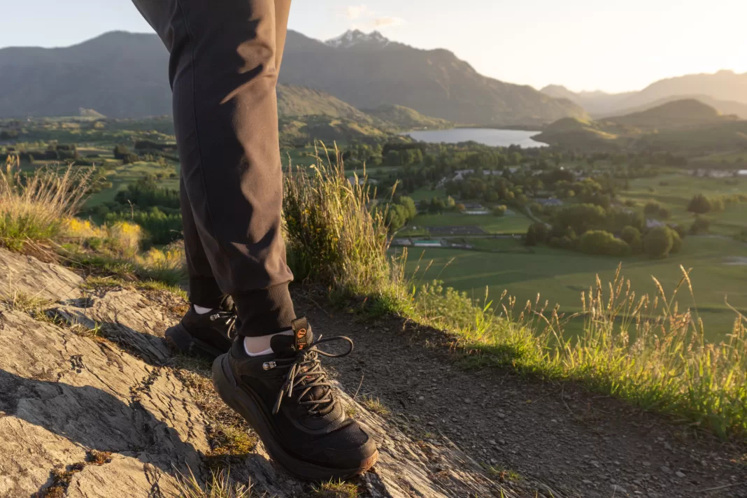 Photo of Timberland Motion Access hiking shoes walking on a trail with a a lake in the background