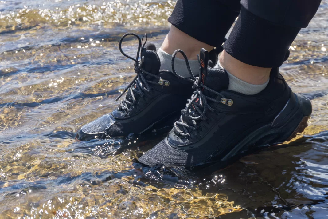 Photo of Timberland Motion Access hiking shoes half submerged in water on a boardwalk