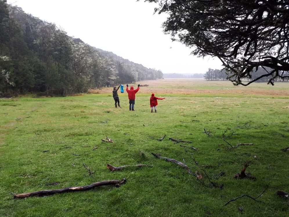 People in a field waving for the rescue helicopter