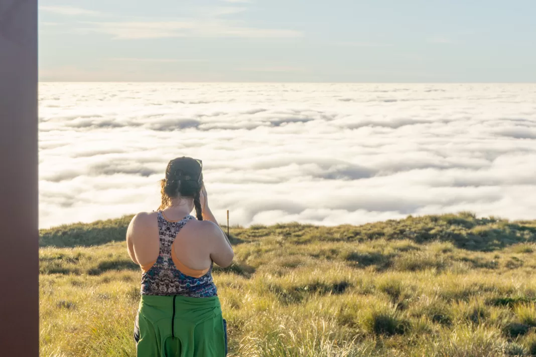 Tramper taking a photo of an inversion layer at Mataketake Hut