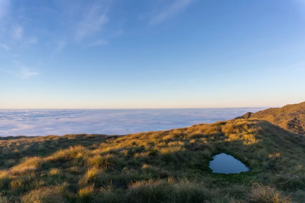 Sunset on mountain tops, tussocks, tarns and an inversion layer