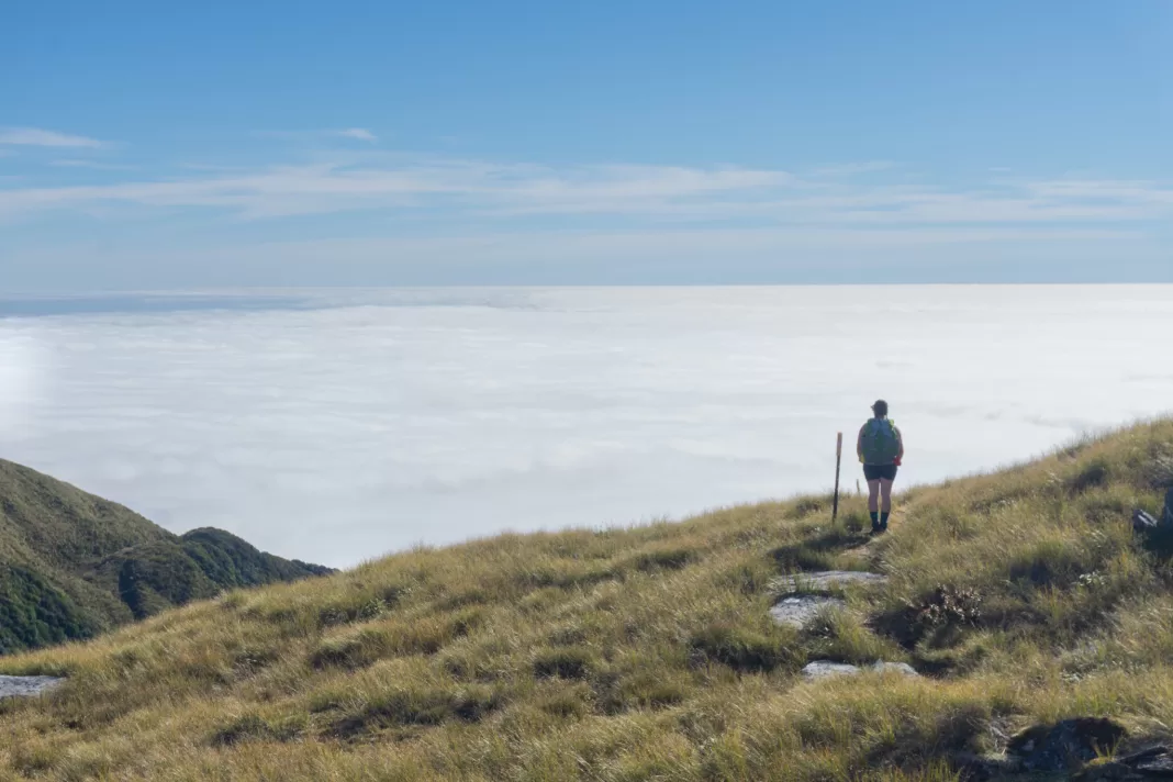 Tramper standing in front of a large inversion layer on the way to Mataketake Hut