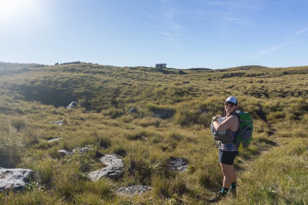 Tramper pointing towards Mataketake Hut