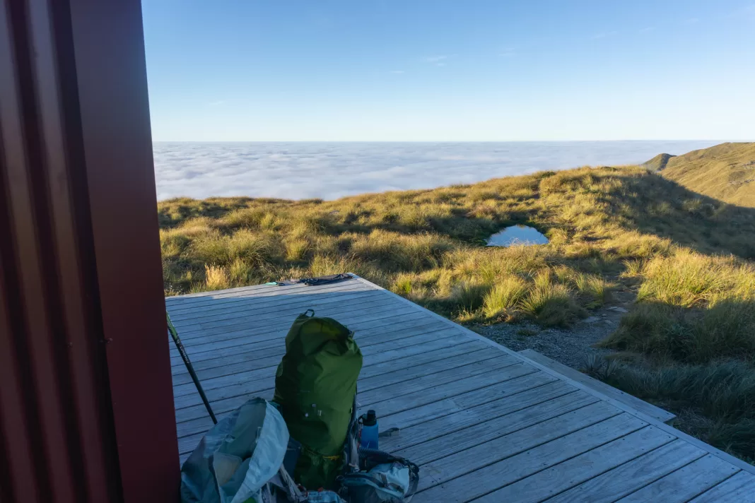 Photo of an Aarn pack on the deck of Mataketake Hut with a cloud inversion layer over the sea