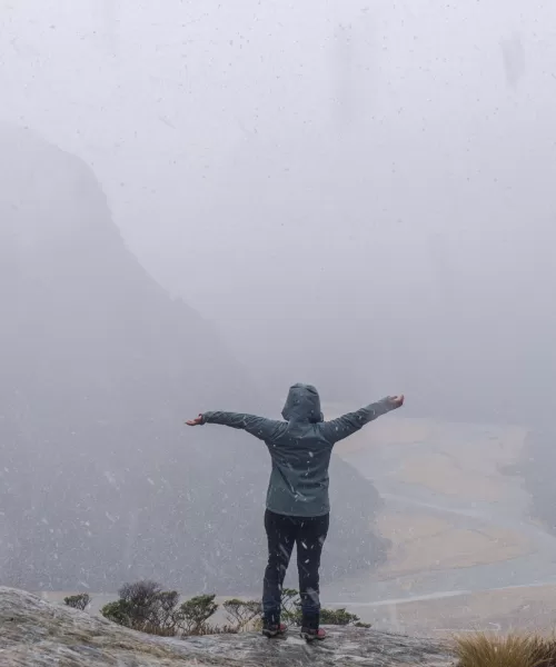 Woman standing in the snow in the mountains