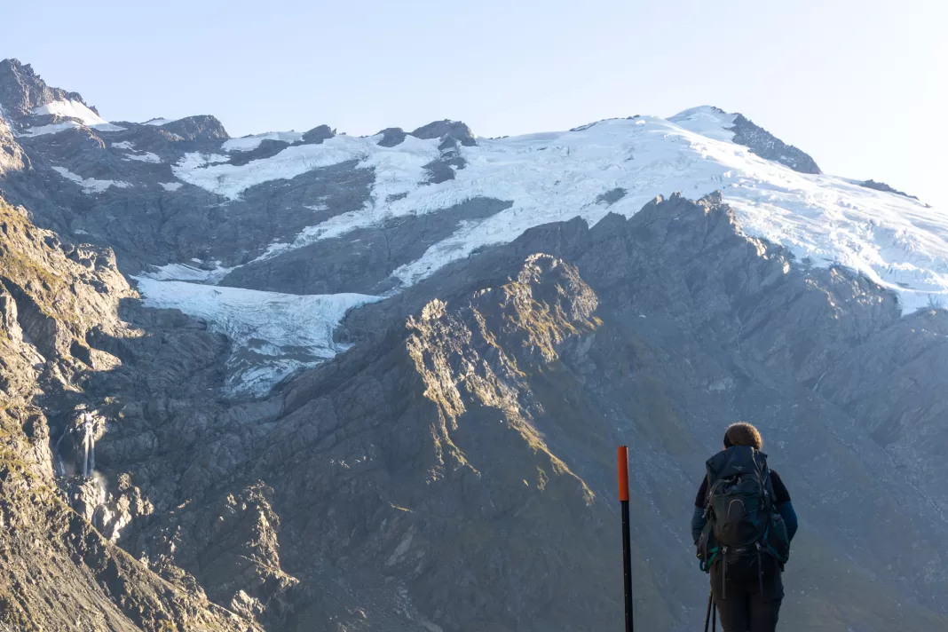 Woman standing silhouetted against Mt Edward and the Marshall Glacier