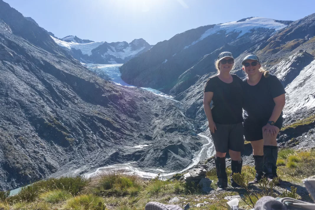 Two woman smiling at the camera with the Dart Glacier in the background